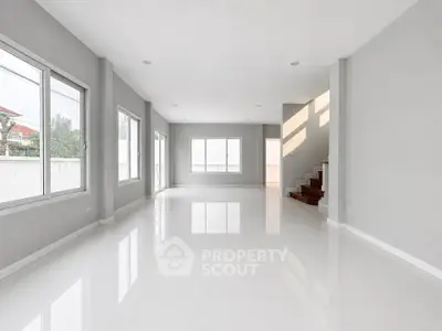 Spacious modern living room with large windows and glossy white floors