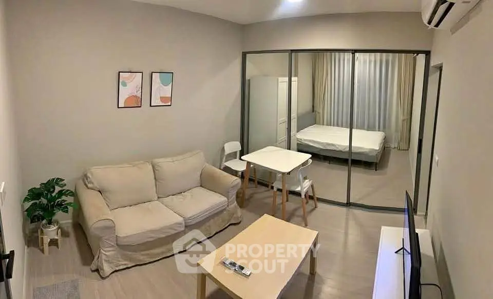 Modern studio apartment with cozy living area and glass partitioned bedroom.