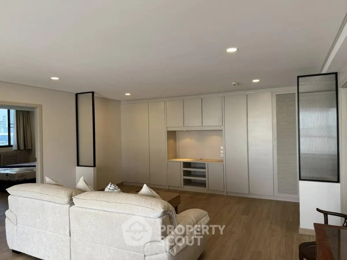 Spacious modern living room with elegant built-in storage and cozy seating area.