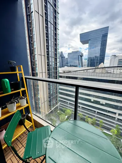 Modern balcony with city view, featuring green furniture and potted plants, ideal for urban living.