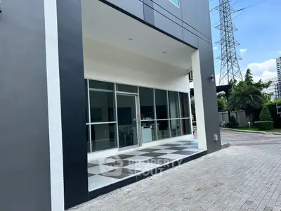 Modern building entrance with sleek glass doors and tiled walkway