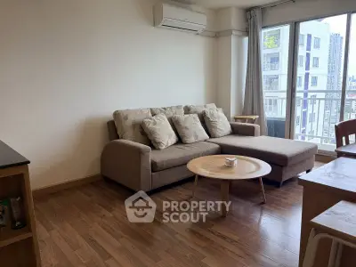 Spacious living room with modern sofa and large window offering city view