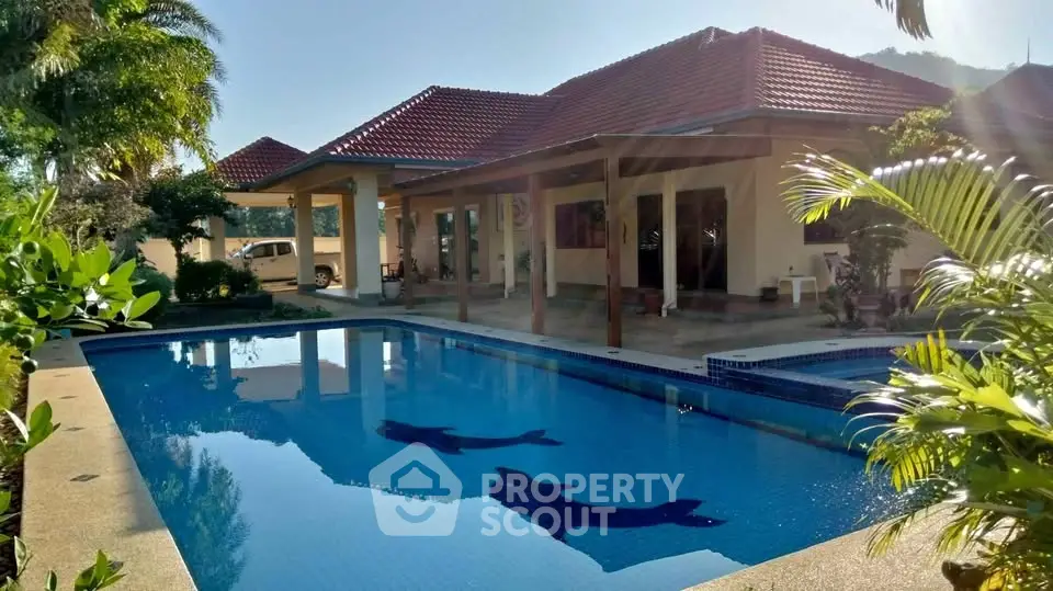 Luxurious villa with private pool and lush garden in tropical setting.