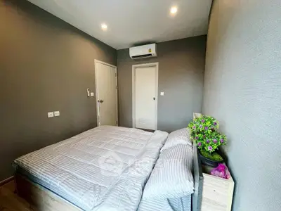 Modern bedroom with cozy bedding and air conditioning in stylish apartment.