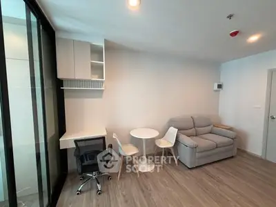 Modern living room with cozy sofa and workspace in open layout apartment.