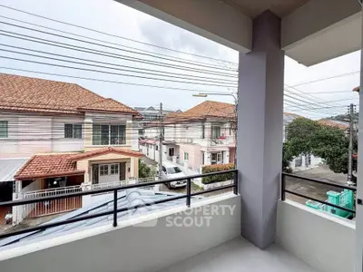 Charming balcony view of suburban neighborhood with tiled roofs and clear skies.
