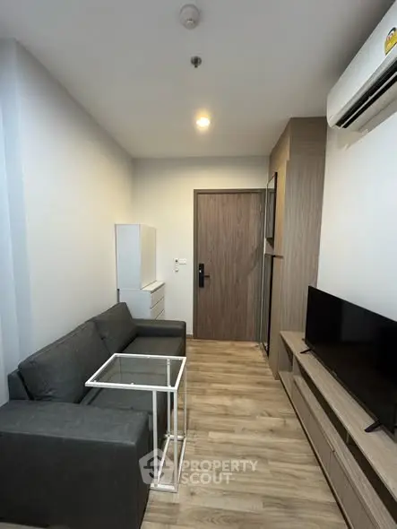 Modern living room with sleek furniture and wooden flooring in a cozy apartment.