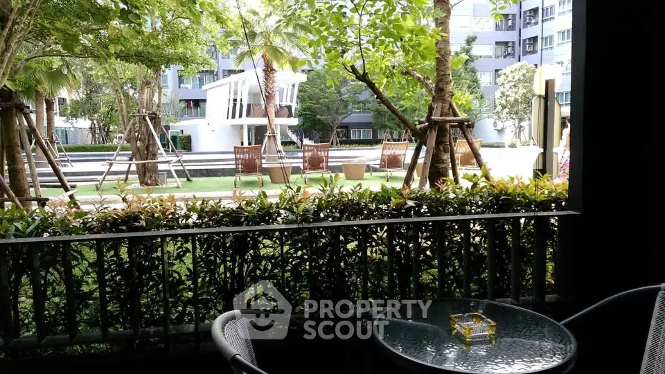 Charming garden view from a cozy balcony with outdoor seating, perfect for relaxation.