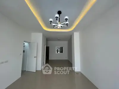 Spacious modern living room with elegant ceiling lighting and glossy tiled floors.