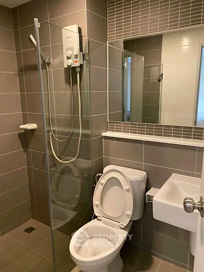 Modern bathroom with glass shower and sleek fixtures in contemporary home.