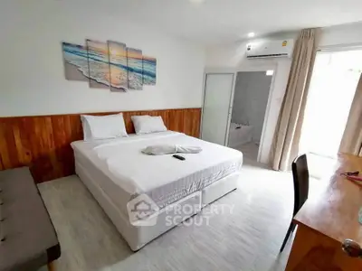 Spacious bedroom with modern decor and ensuite bathroom, featuring a comfortable king-size bed and natural light.