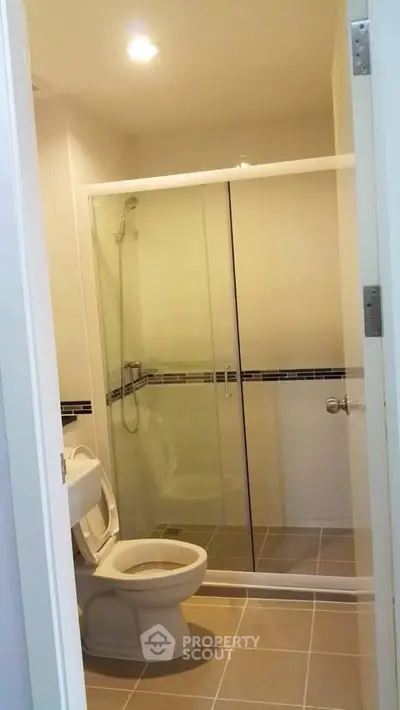 Modern bathroom with glass shower enclosure and tiled flooring