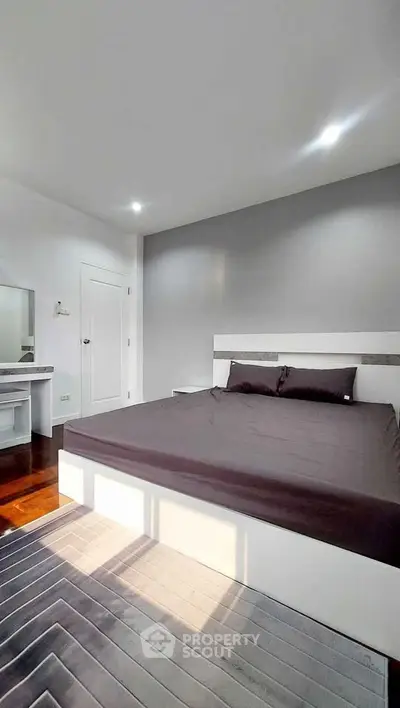 Modern bedroom with sleek design and natural light, featuring a stylish bed and elegant decor.