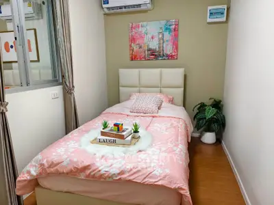Cozy bedroom with stylish decor and air conditioning, perfect for relaxation.