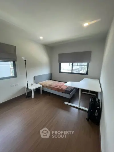 Modern minimalist bedroom with sleek furniture and ample natural light.