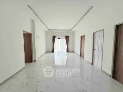 Spacious and bright living room with marble flooring and large windows.