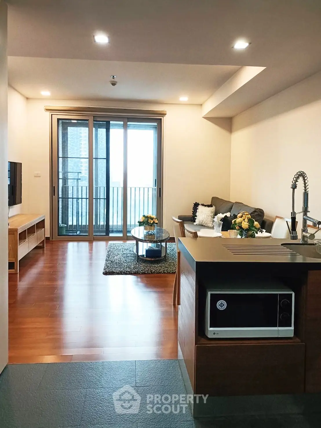 Modern open-layout living room with sleek kitchen and balcony view