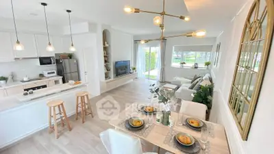 Spacious open-plan living room and kitchen with modern decor and natural light.
