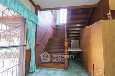 Charming wooden staircase with natural light and vintage decor in cozy home interior.