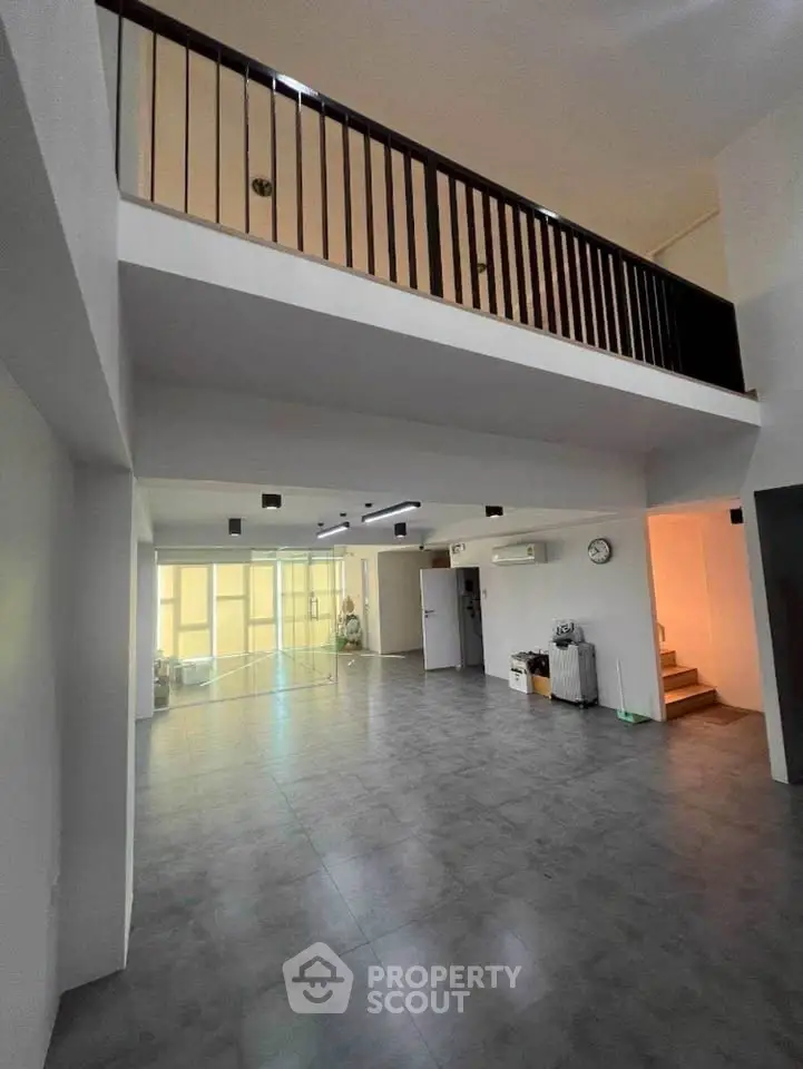 Spacious modern living room with high ceiling and mezzanine level