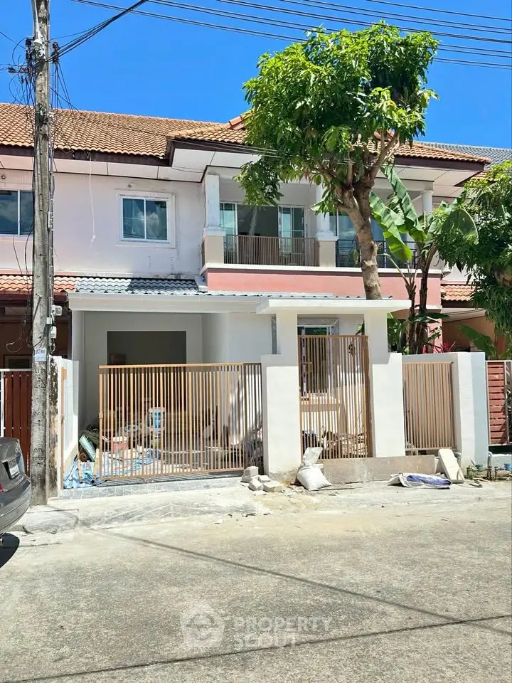 Charming two-story townhouse with modern facade and gated entrance in a serene neighborhood.