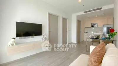 Modern living room with open kitchen, sleek TV setup, and stylish decor