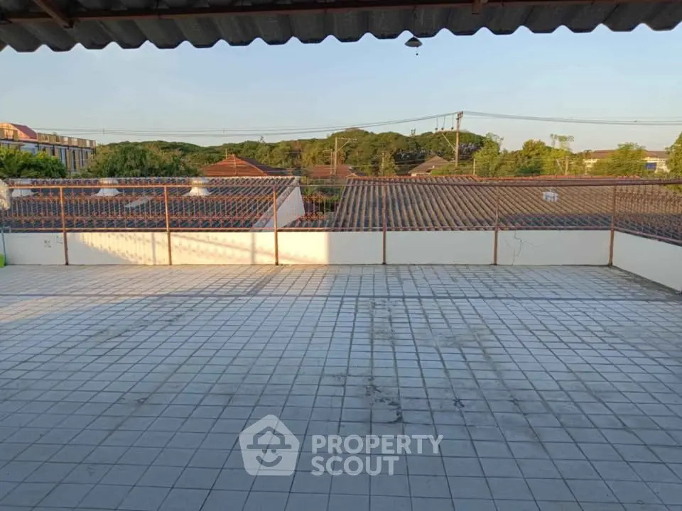 Spacious rooftop terrace with scenic views of surrounding rooftops and greenery.