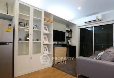 Modern living room with sleek furniture and city view, featuring a stylish entertainment center and cozy ambiance.