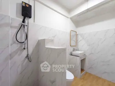 Modern minimalist bathroom with marble tiles and sleek fixtures