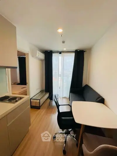 Modern compact living room with sleek furniture and large window view