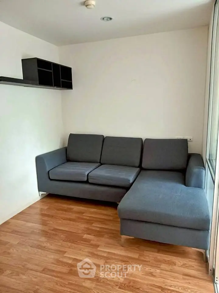 Cozy living room with modern gray sectional sofa and wooden flooring