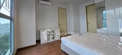 Modern bedroom with large window and air conditioning in a high-rise apartment.
