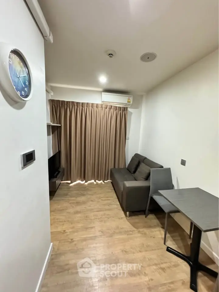 Cozy living room with modern sofa and wall-mounted TV, perfect for relaxing evenings.