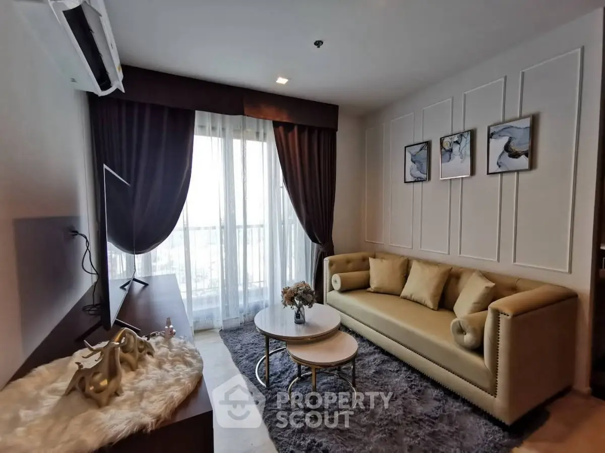 Elegant living room with plush sofa, stylish decor, and large window offering natural light.