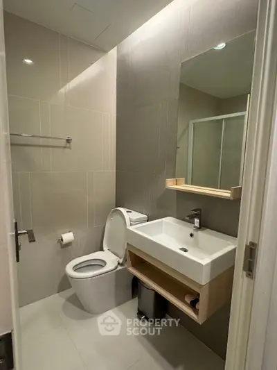 Modern bathroom with sleek fixtures and neutral tones, featuring a spacious shower area.