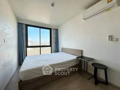 Modern bedroom with large window and air conditioning in urban apartment