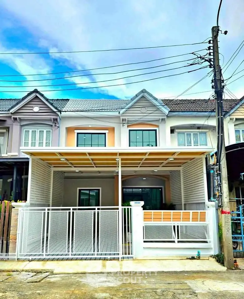 Charming townhouse with modern facade and gated entrance in a serene neighborhood.