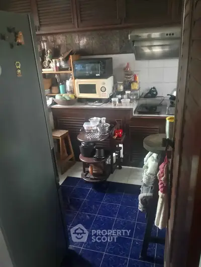 Cozy kitchen with microwave, gas stove, and ample storage in a compact layout.