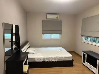 Spacious bedroom with modern furnishings and natural light, perfect for relaxation.