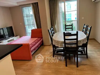 Cozy living room with dining area and balcony view in modern apartment.