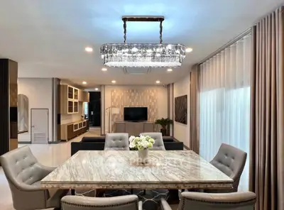 Luxurious open-plan living room with elegant dining area and modern chandelier.