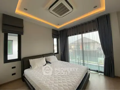 Spacious bedroom with modern design and large windows offering natural light.