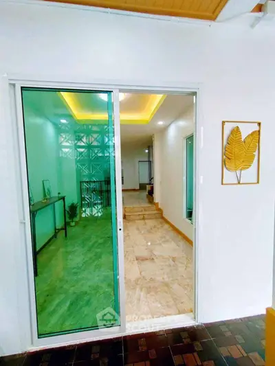 Elegant entrance with glass sliding door and marble flooring