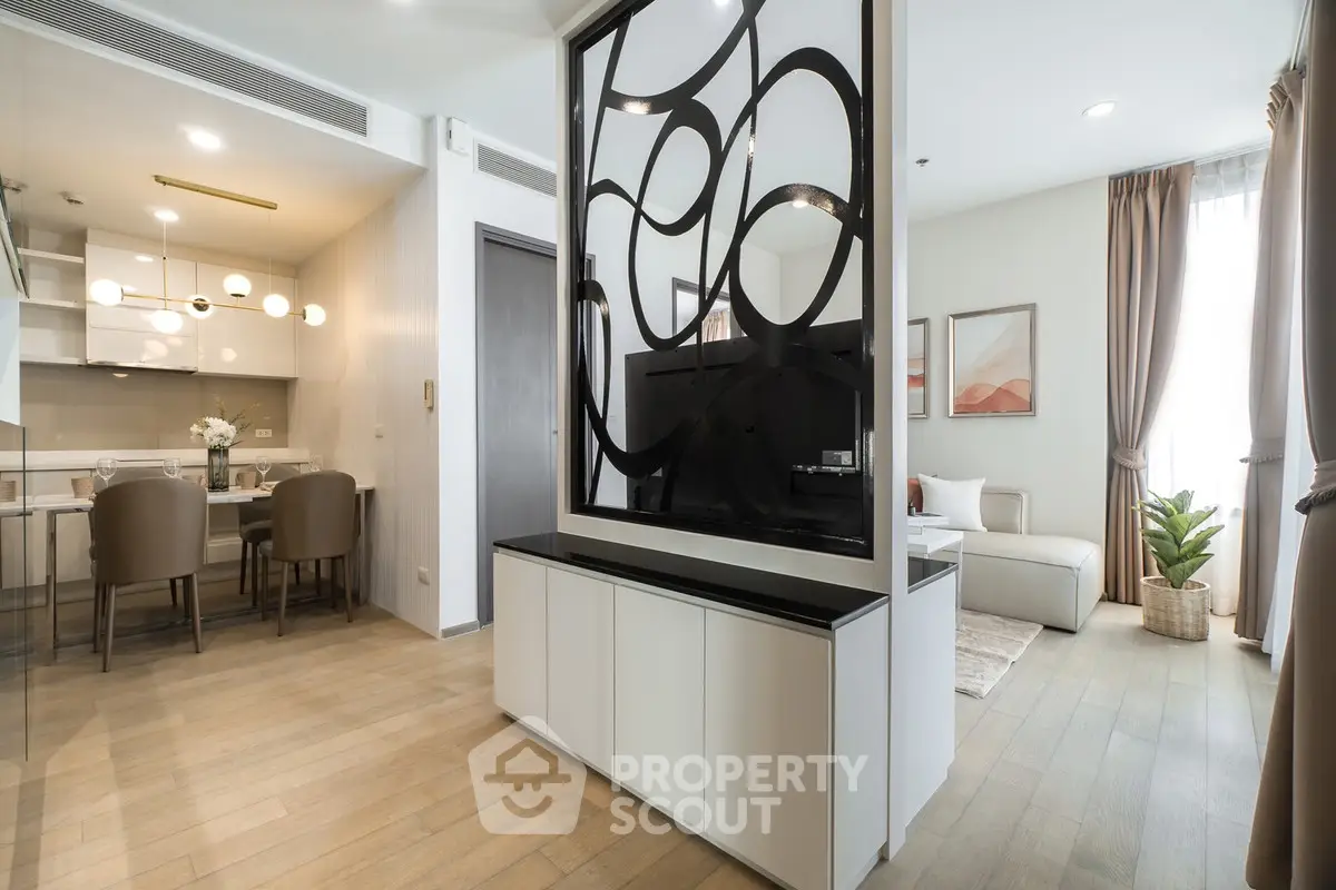 Modern open-plan living room with stylish partition and dining area in a contemporary apartment.