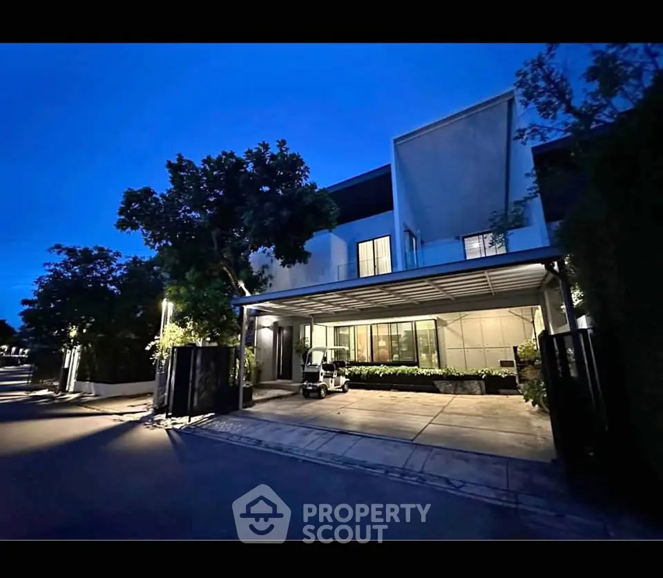 Modern luxury home exterior with sleek design and spacious driveway at dusk.