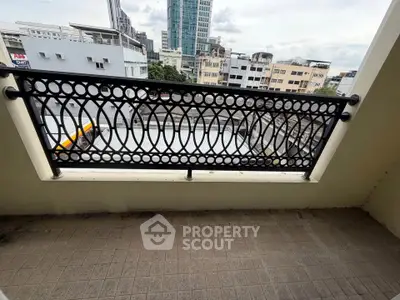 Charming balcony with decorative railing and cityscape view, perfect for urban living.