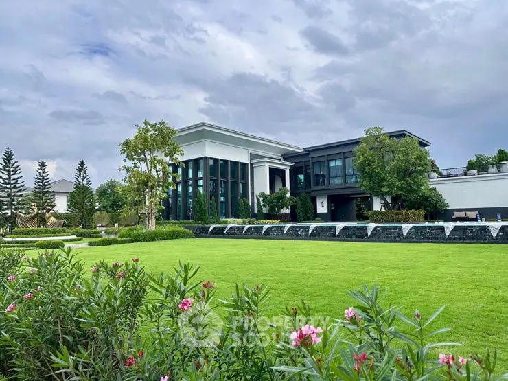 Luxurious modern building with lush green garden and elegant landscaping.