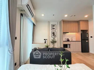 Modern living room with open kitchen, featuring sleek design and natural light.