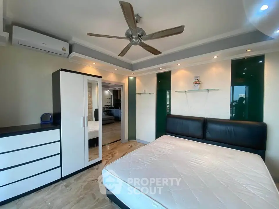 Modern bedroom with stylish ceiling fan and sleek furniture design.
