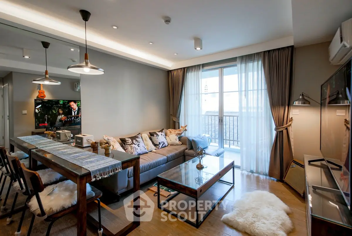 Stylish modern living room with balcony, cozy seating, and elegant decor in a high-rise apartment.